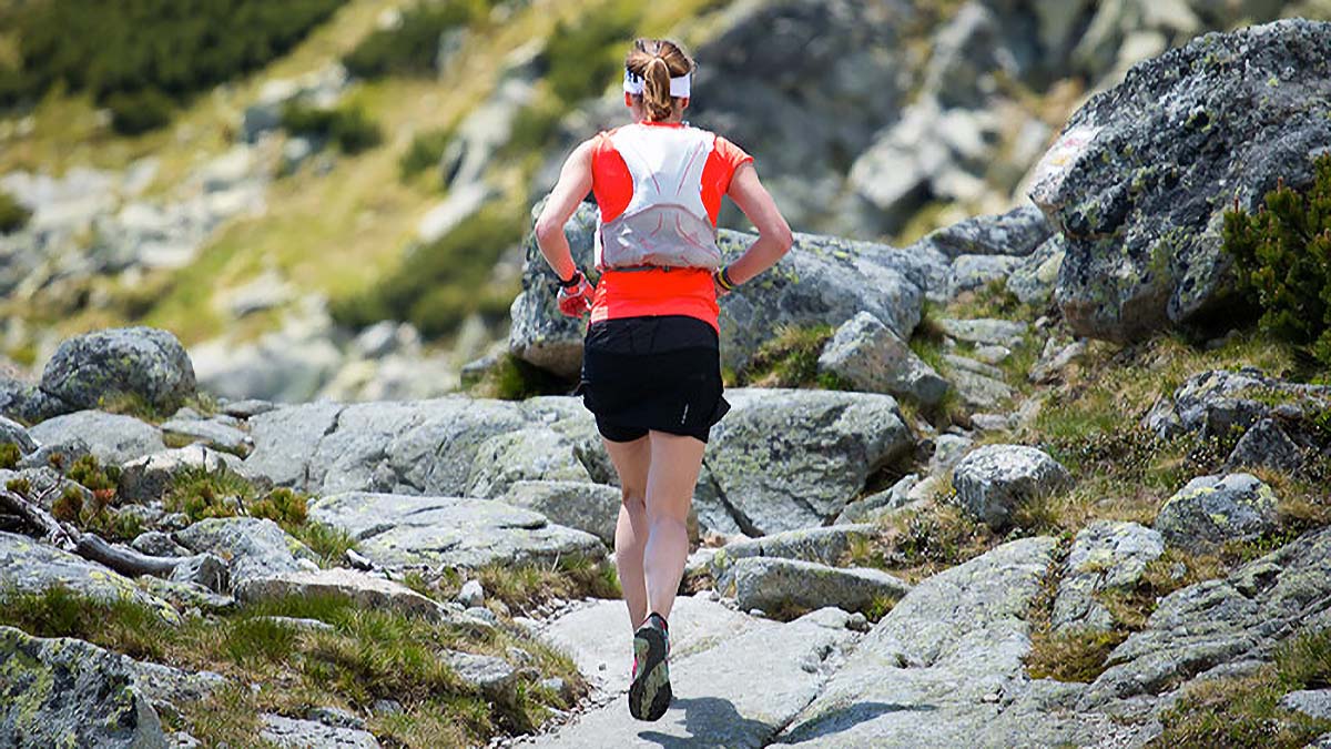A Female Trail Runner On A Rocky Trail Above Tree Line