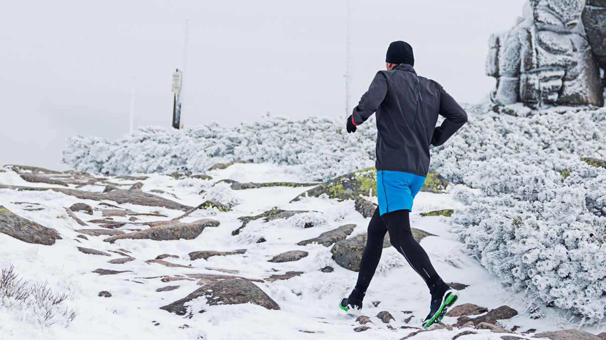 Warm Dressed Runner Running On The Frozen Snowy Trail In Cold Wi