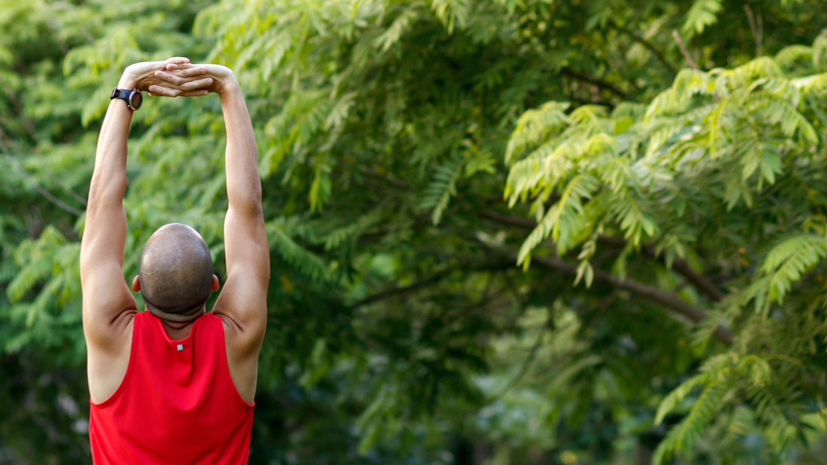 A Man Stretching In The Park Before Running At The Morning. Heal