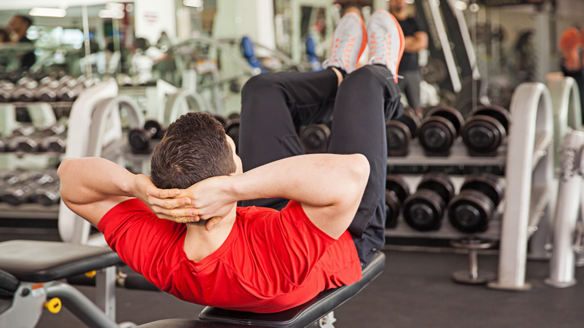 Young Man Doing Crunches On A Bench