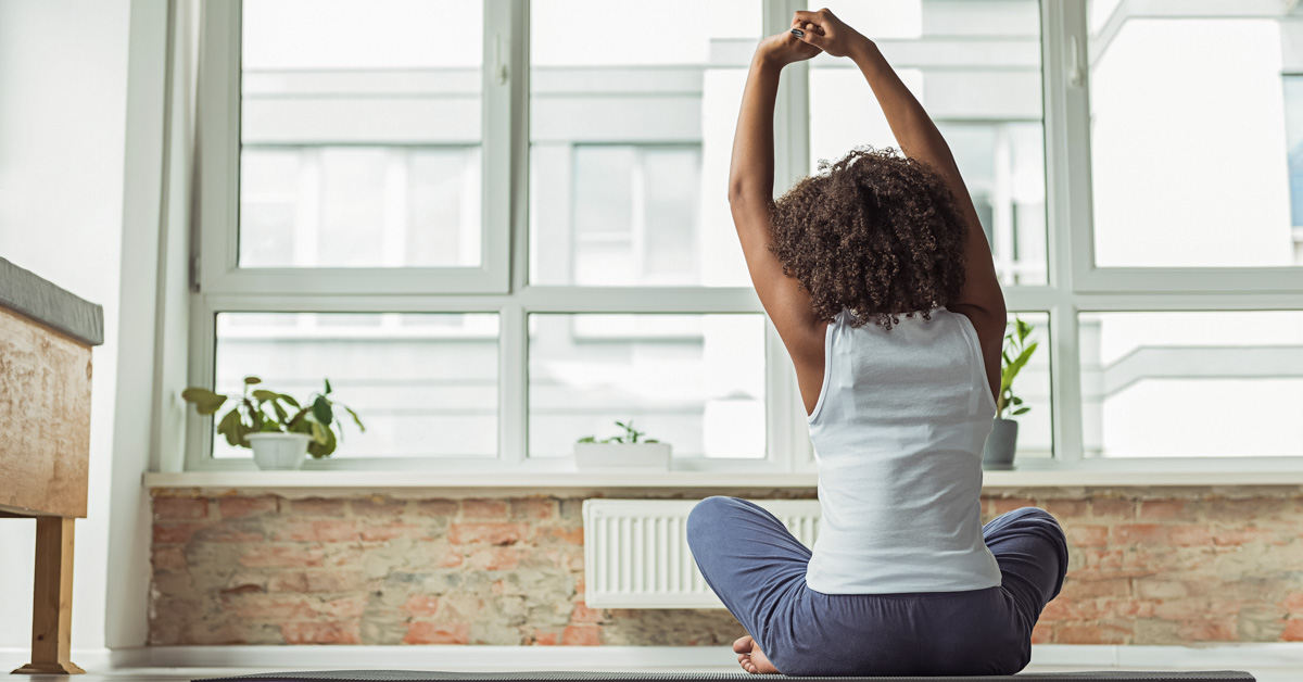 Female Practicing Yoga On Mat At Home