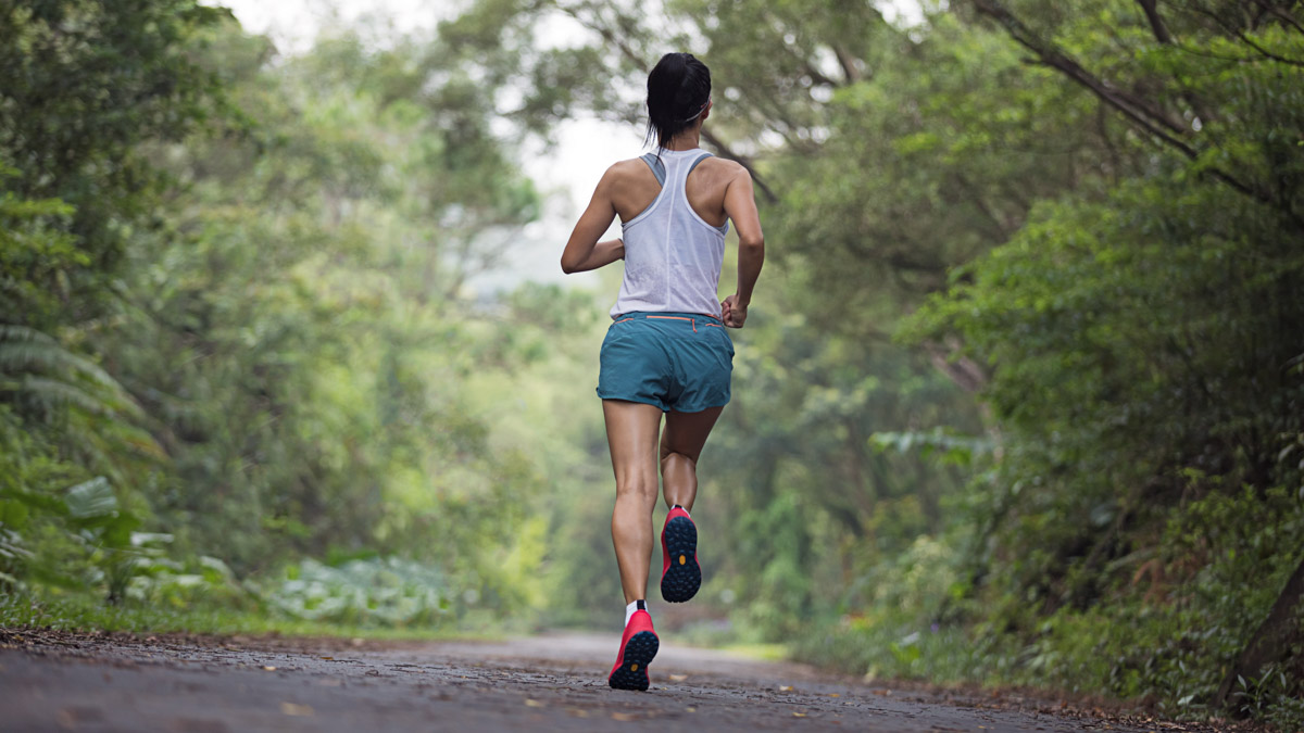 Female Runner Running At Summer Park Trail . Healthy Fitness Woman Jogging Outdoors.