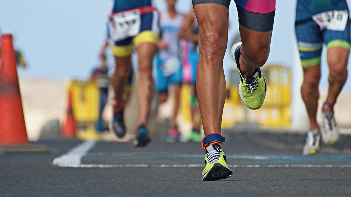 Fit Runner's Legs With Yellow Running Shoes Racing In Ironman