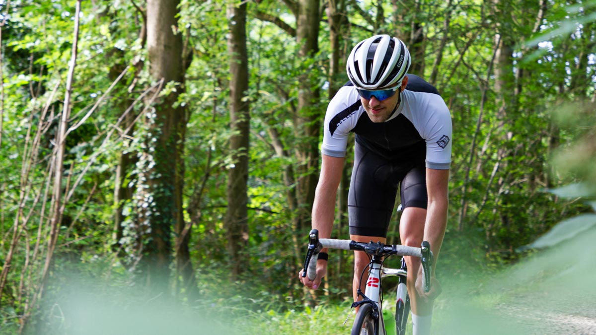 Photo Of A Cyclist On Zone 2 Training Ride Through Lush Green Forest Peeking Through Trees