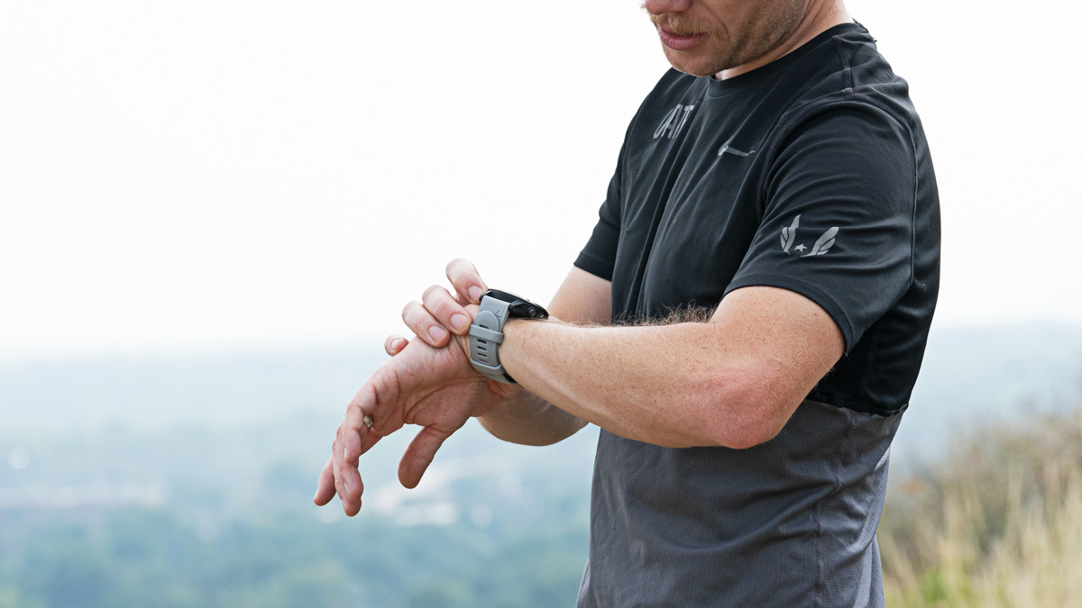Image Of Trainingpeaks Ambassador Andrew Simmons Assesses Trainingpeaks Metrics For Runners On His Watch While Doing A Trail Run