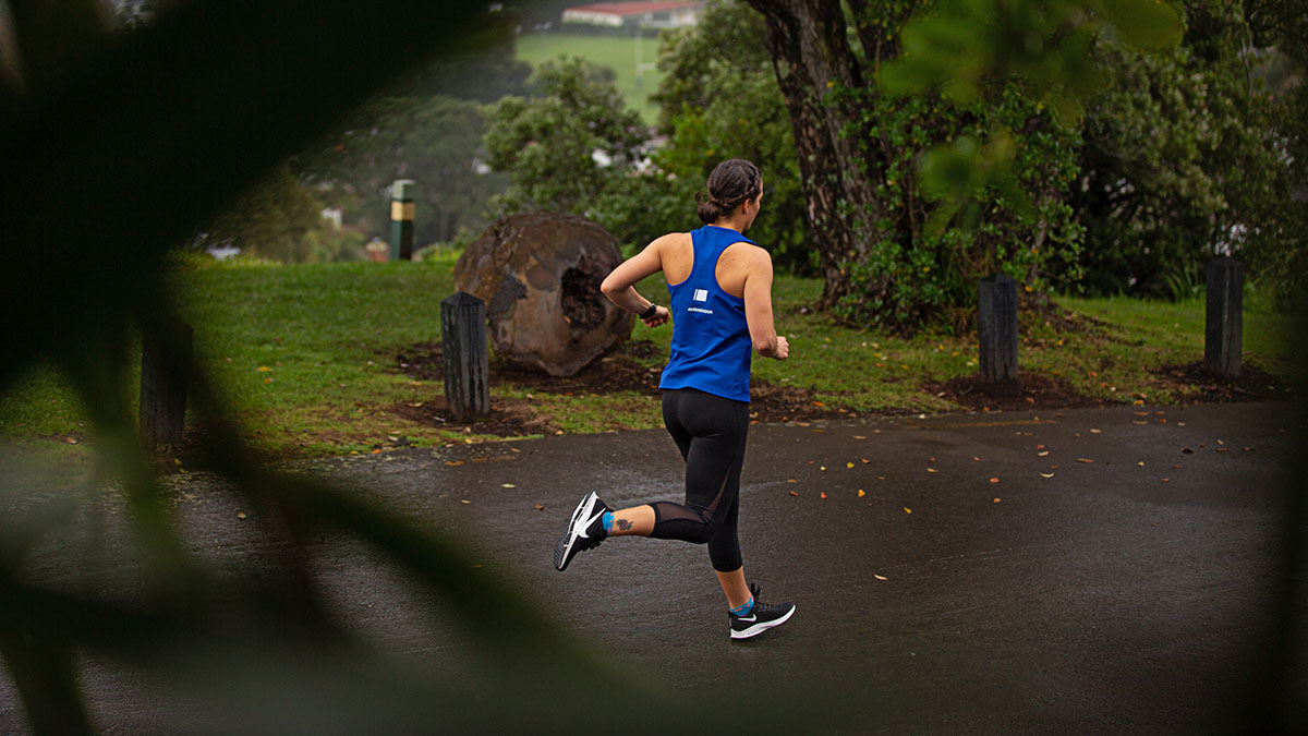 A Woman Running On A Multi User Path In The Rain