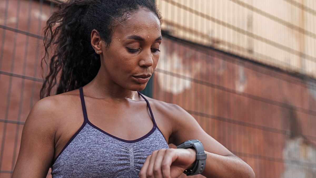 Image Depicting An Athlete Looking At Their Watch For Workout Guidance In Terms Of Macrocycle, Mesocycle, And Microcycle