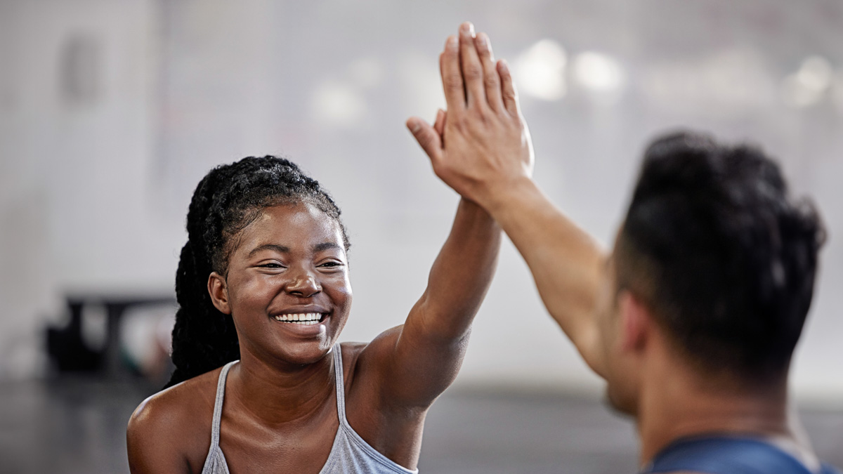 Image Of A Young Female Athlete And Her Coach High Fiving After Training
