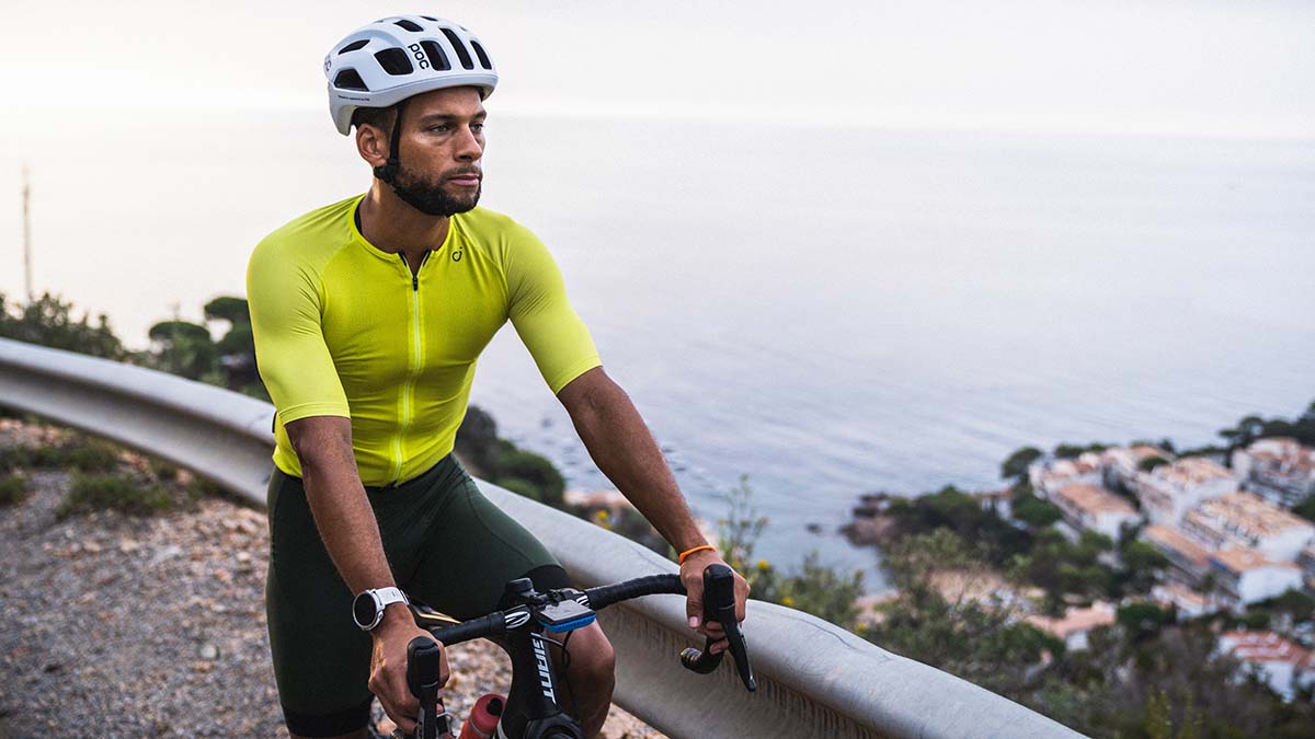 A Male Cyclists Stopping At An Overlook Above A Seaside City In Europe