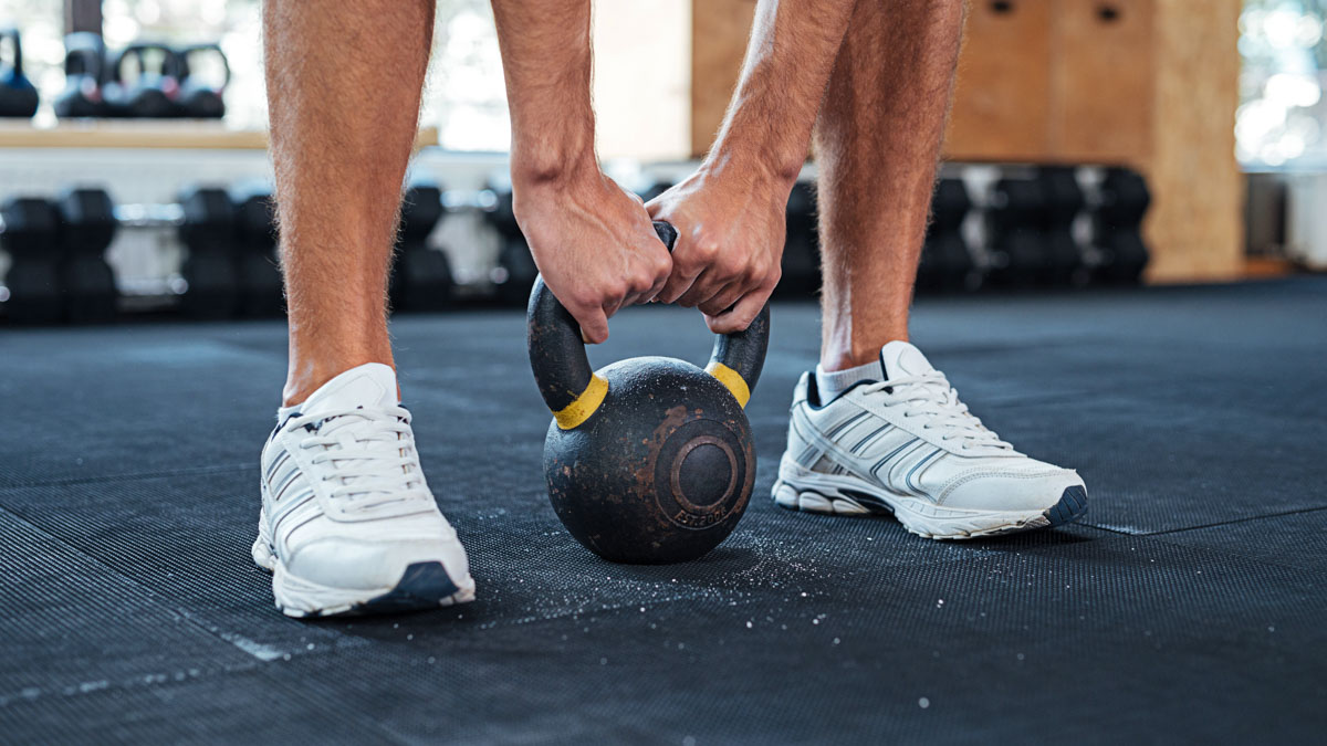 Athletic Male Legs In Gym, Man Holding Kettleball