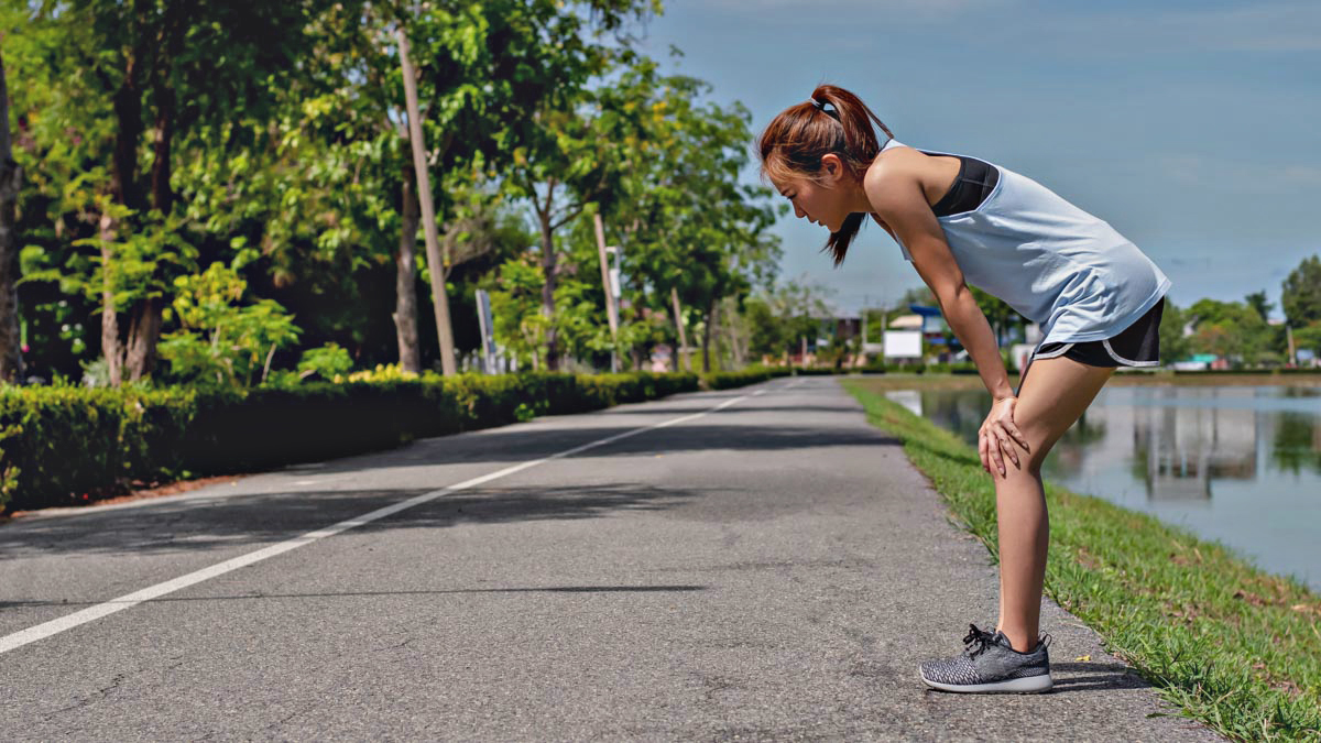 Asian Women Exercising. She Is Running On The Street, She Is Tir