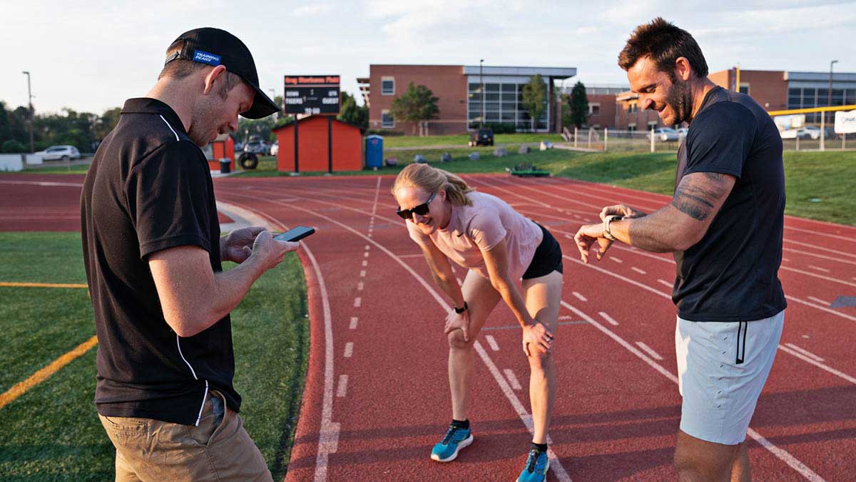 A Coach With A Female And Male Runner After A Workout At A Track