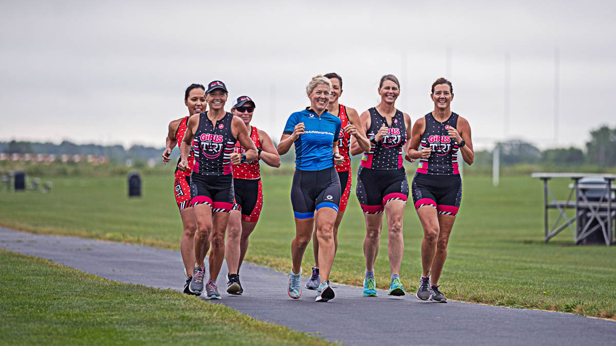 A Group Of Female Runners From A Club Run With Their Coach In A Trainingpeaks Jersey