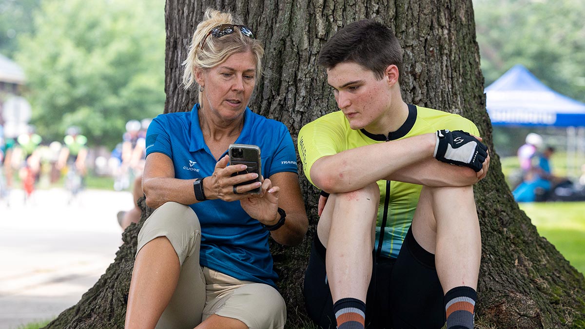 A Female Coach Talks With A Young Male Cyclist After A Race