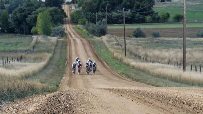 Image Of A Pack Of Cyclists Doing A Gravel Grinder On A Dirt Road