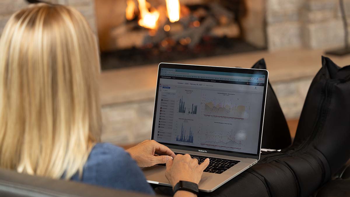 A Woman On Her Couch With Recovery Boots On Looking At Her Trainingpeaks Data