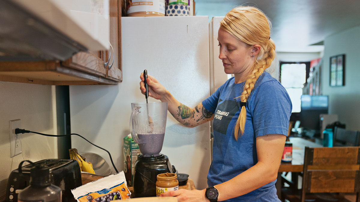 A Woman Making A Plant Based Smoothie In Her Kitchen