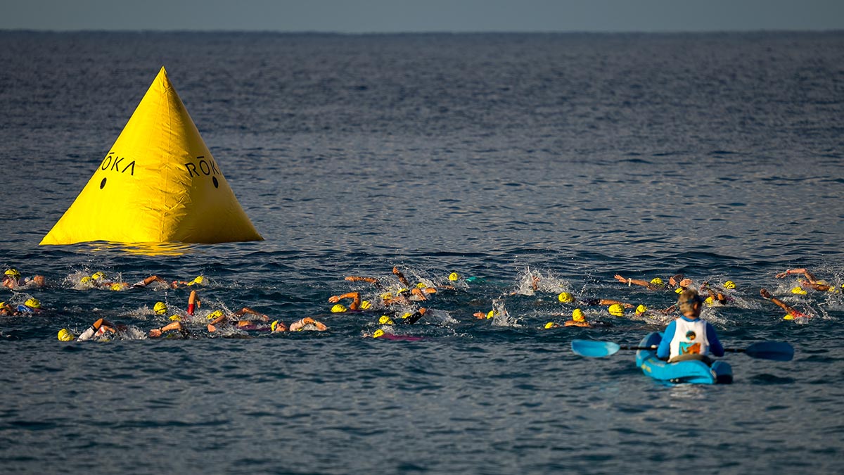 Dozens Of Swimmers Make Their Way By A Buoy During The Swim Portion Of The 2022 Ironman World Championships In Kona.